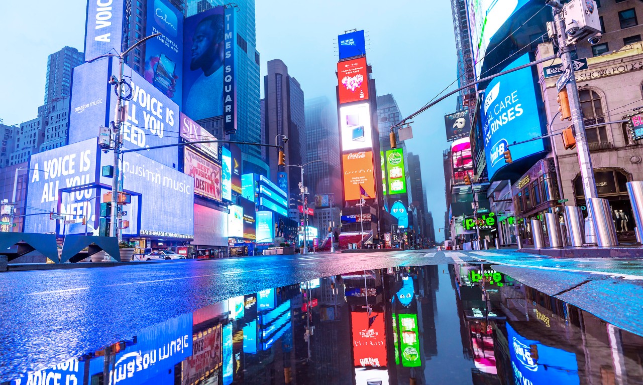 Colorful Digital Billboards reflect to the puddle on the road.