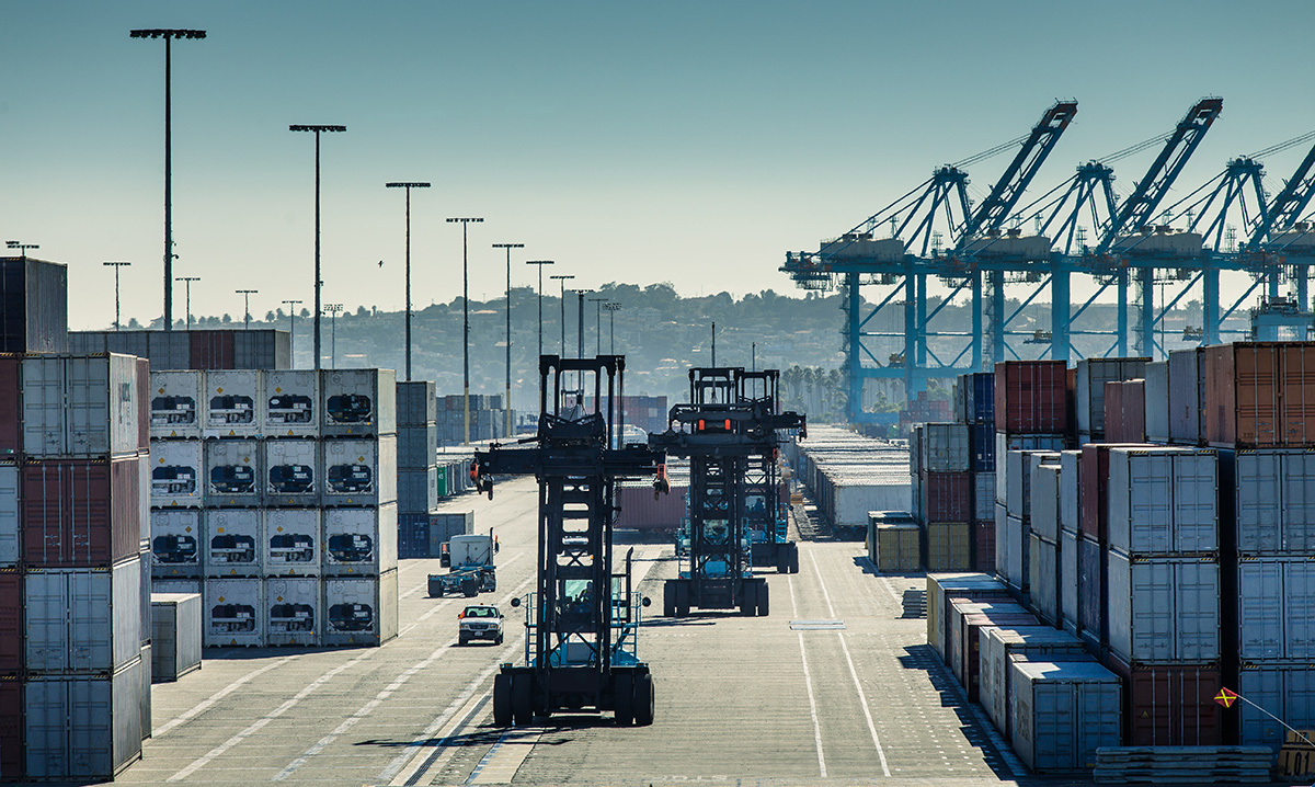 Forklift trucks move between rows of stacked containers at the Port of Los Angeles/Long Beach..