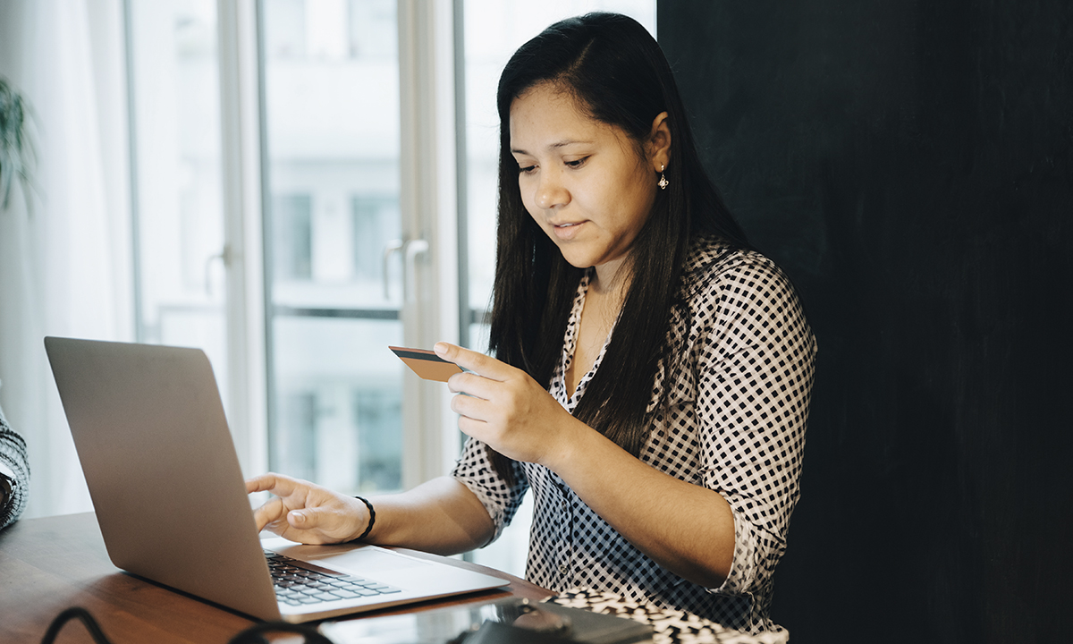 YOUNG WOMAN USING PHONE ON TABLE