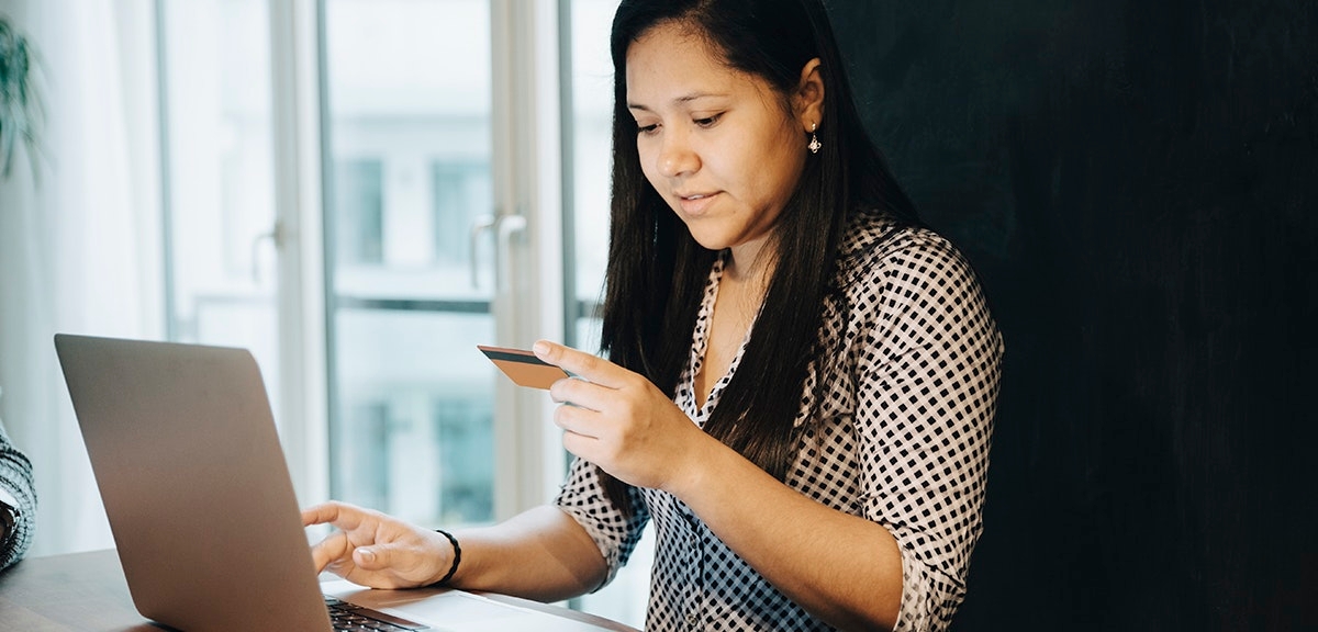 YOUNG WOMAN USING PHONE ON TABLE