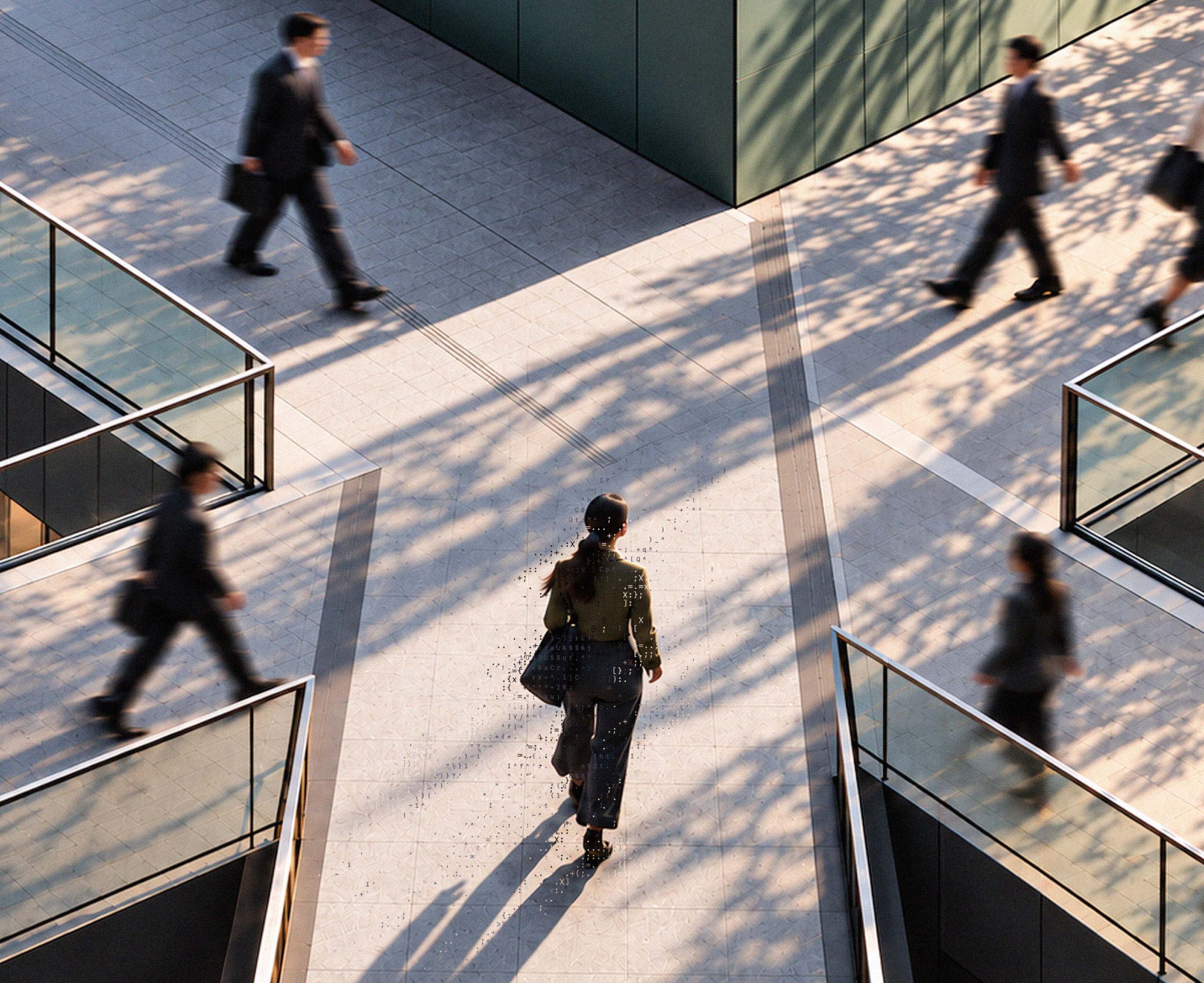 People crossing a geometric city plaza viewed from above