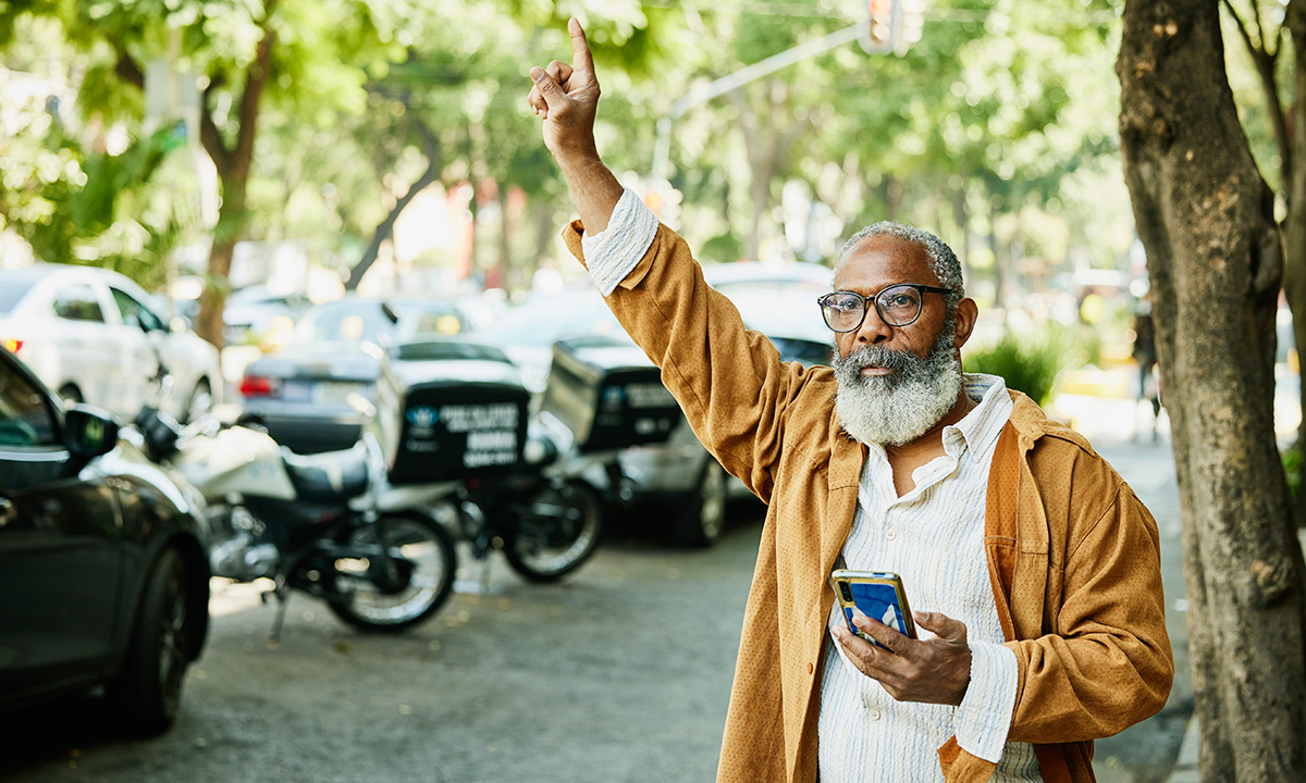 A man using a ride-hailing app on a city street.